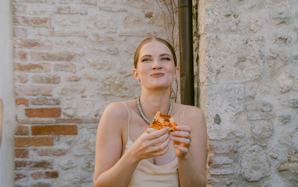 Braut isst Pizza am Hochzeitstag